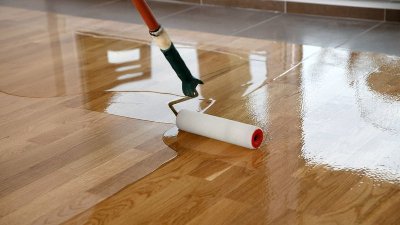 Floor being varnished using a roller
