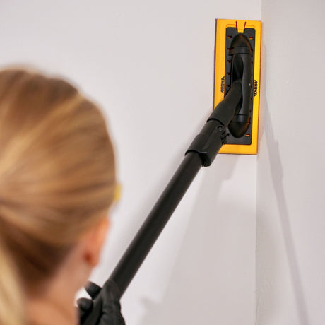 Mirka Deco Sander 80 x 230mm rectangular head in use sanding edges on a wall 